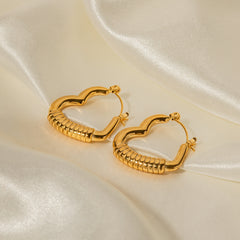 Side view of unique heart-textured gold earrings with modern shape