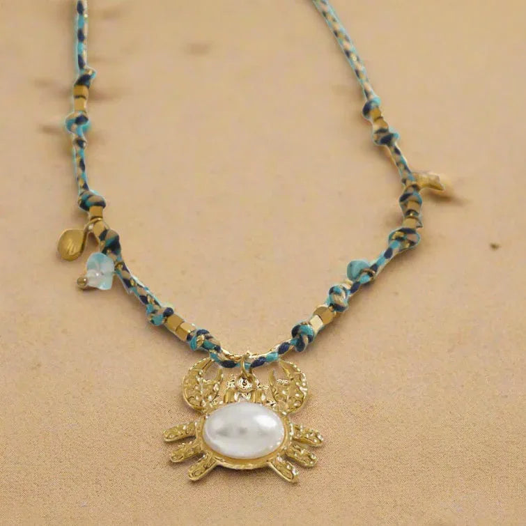 Ocean-inspired gold necklace with crab, shell, and starfish