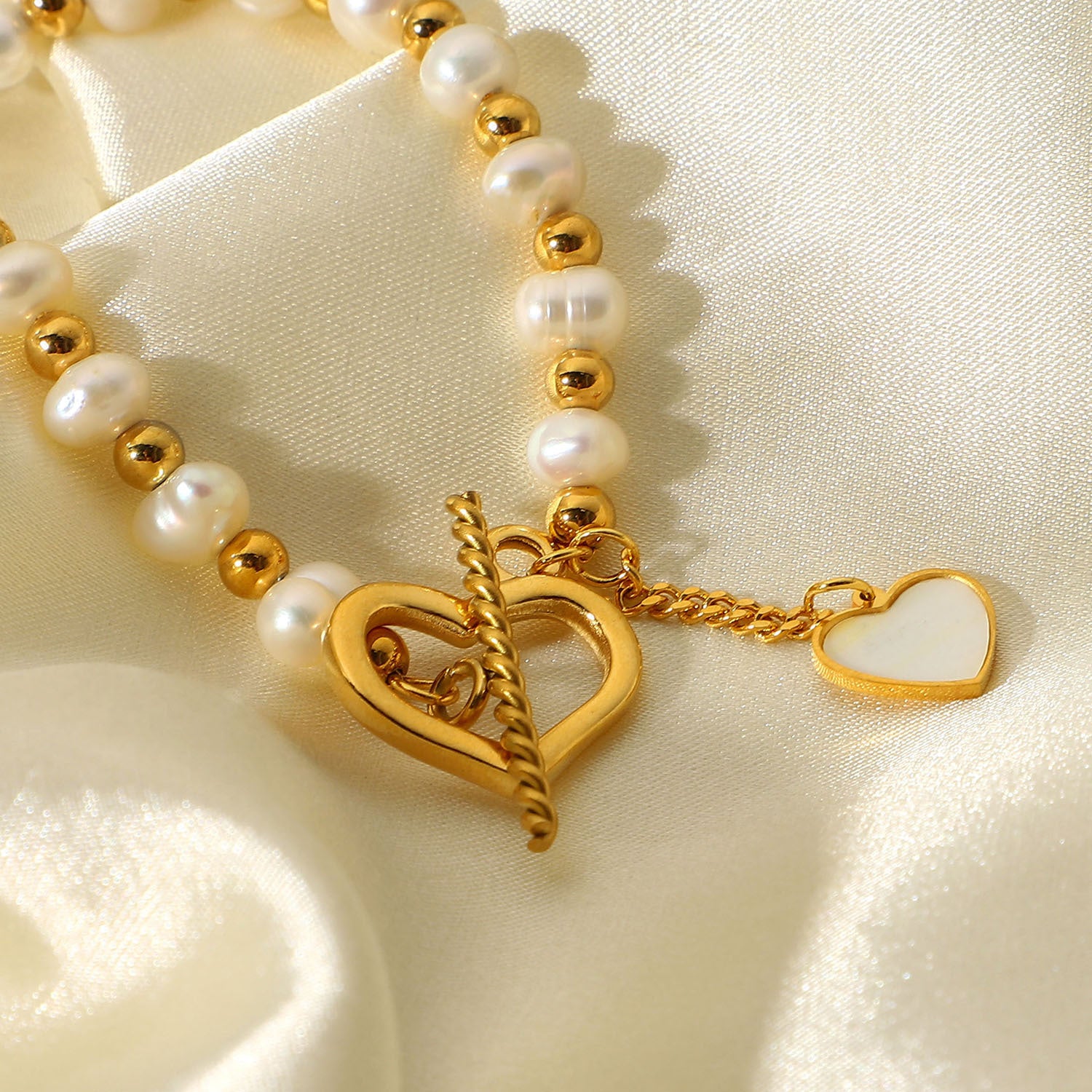 Elegant pearl heart charm on gold bracelet with toggle closure