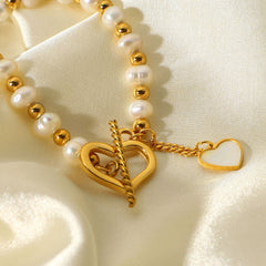 Elegant pearl heart charm on gold bracelet with toggle closure
