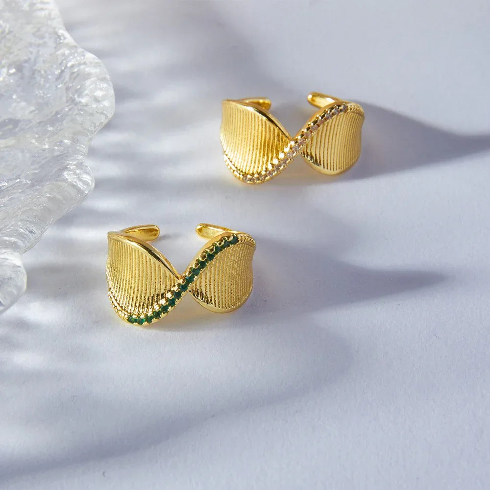 Side profile of gold twist ring showing elegant curve and diamond placement