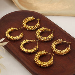 Close-up of Eterna Loop C-shaped gold earrings with smooth polish
