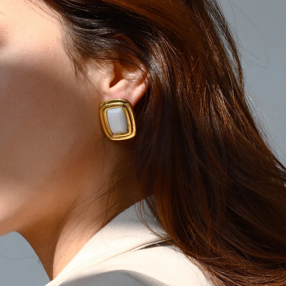 Model wearing GeoCurve earrings with slick hair and blazer
