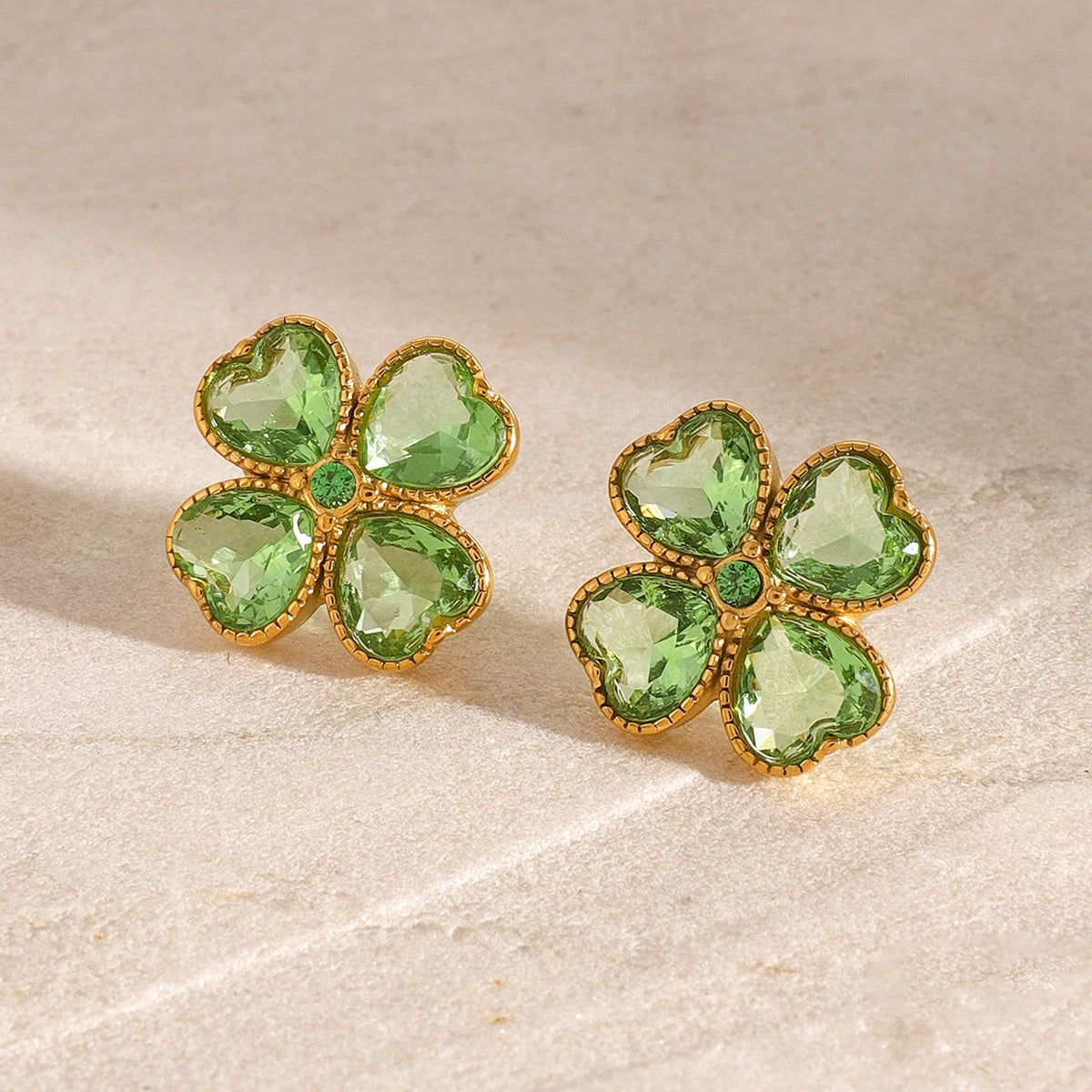 Delicate gold earrings featuring symbolic clover shape and sparkle