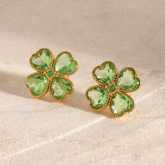 Delicate gold earrings featuring symbolic clover shape and sparkle
