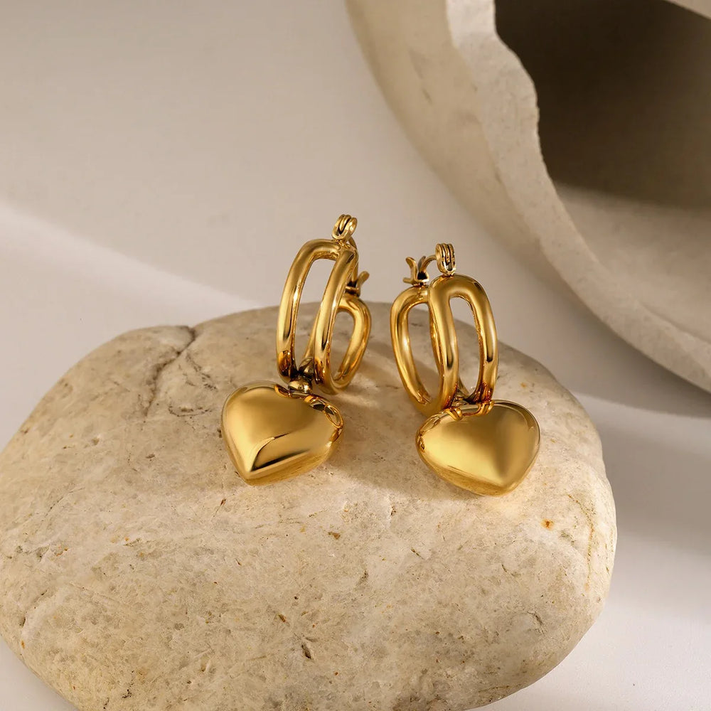 Side angle of sliding heart earrings reflecting movement and light