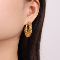 Pair of Eterna Loop gold earrings displayed