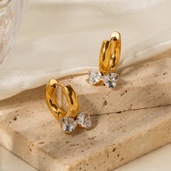 Side view of 3D bow knot earrings in gold showing interlocked hearts