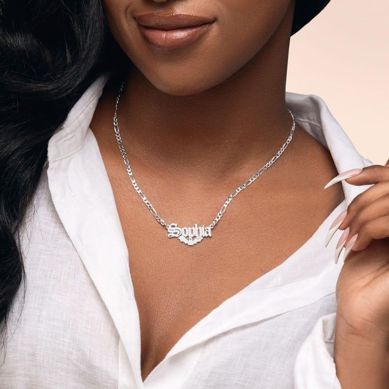 Model wearing bat-shaped silver name necklace with streetwear outfit