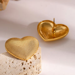 Detailed texture on gold heart-shaped earrings for romantic styling