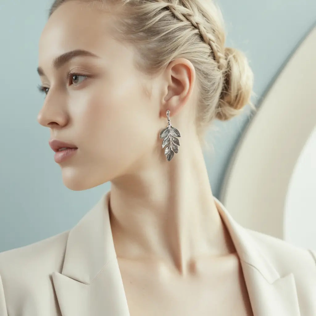 Woman wearing a silver leaf earring against a light background - Argesteel