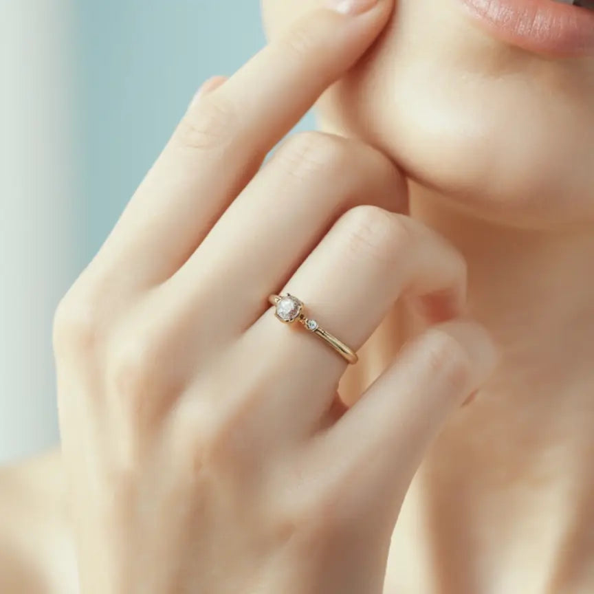 Gold ring with a diamond on a hand against a light background - Argesteel